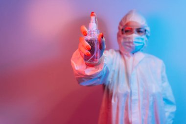 Kadın doktor virüs enfeksiyonu ve vebayı önlemek için el dezenfektanı kullanıyor..