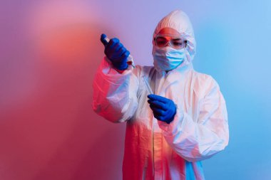 Koruyucu yüz maskesi ve enjeksiyonu dolduran eldivenli genç bir doktor. Tıbbi enfeksiyonlar konsepti durdurur. COVID-19 kavramını bırak. Covid-19 koruması. Salgın, salgın