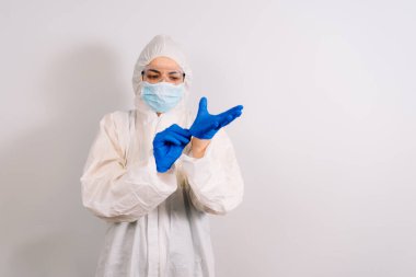COVID 19 enfeksiyonunu korumak için maske, gözlük ve takım elbise takan bir doktor.