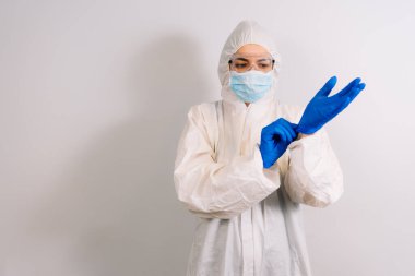 COVID 19 enfeksiyonunu korumak için maske, gözlük ve takım elbise takan bir doktor.