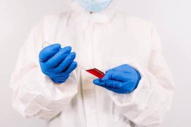 Doktorun elleri şırıngayı koronavirüs aşısıyla dolduruyor, iğneye hazırlanıyor. Covid-19 koruması. Salgın, salgın, aşı konsepti. Yeni aşıyı test ediyorum. Koruyucu kıyafetli doktor.