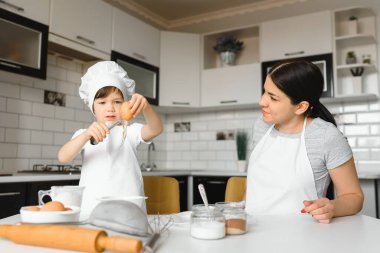 Mutlu bir aile. Anne oğluna sabahları kek menüsünü nasıl yapacağını öğretiyor. Sağlıklı yaşam tarzı konsepti Noel pastası pişirmek ve yemek pişirme konsepti.