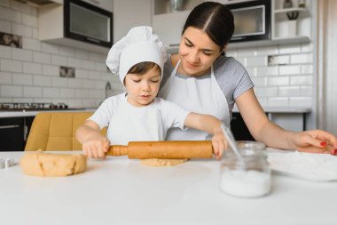 Mutlu anne ve çocuk mutfakta kurabiye hazırlıyor.
