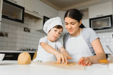 Mutlu anne ve çocuk mutfakta kurabiye hazırlıyor.