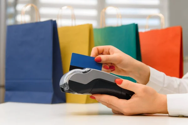 Hand with credit card swipe through terminal for sale in supermarket. credit card payment through a shopping terminal at shopping