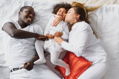 Küçük kız çocuğu olan heyecanlı, çok kültürlü, genç bir aile iyi eğlenceler, aşırı mutlu. Uluslararası anne ve baba küçük kızla oynar, hafta sonunun tadını çıkarırlar.
