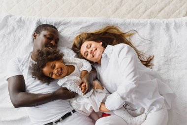 Küçük kız çocuğu olan heyecanlı, çok kültürlü, genç bir aile iyi eğlenceler, aşırı mutlu. Uluslararası anne ve baba küçük kızla oynar, hafta sonunun tadını çıkarırlar.