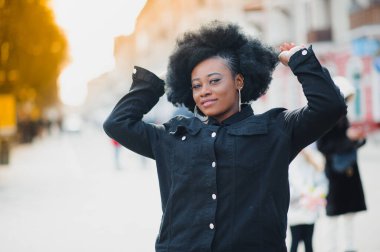Saçlarını kestirmiş güzel bir kız sokakta yürüyor.