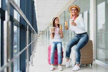 Uçak kalkmadan önce ailesi havaalanında. Anne ve çocuk modern uluslararası terminalin kalkış kapısında binmek için bekliyorlar. Çocuklarla seyahat ve uçmak. Anne ve bebek uçağa biniyor..
