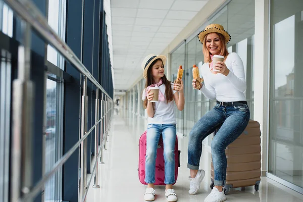 Uçak kalkmadan önce ailesi havaalanında. Anne ve çocuk modern uluslararası terminalin kalkış kapısında binmek için bekliyorlar. Çocuklarla seyahat ve uçmak. Anne ve bebek uçağa biniyor..