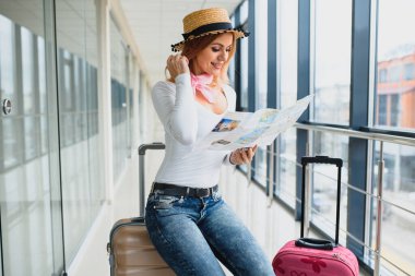 Havaalanı terminalinde bavuluyla yürüyen bir kadın, seyahat konsepti. Yüksek mevsim ve tatil konsepti. Rahatla ve yaşam tarzını değiştir. Seyahat ve Tatil Konsepti.