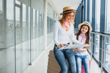 Havaalanında birlikte seyahat eden mutlu bir anne ve kız.