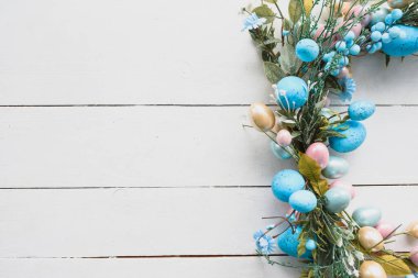 Paskalya Yumurtaları Bahar Arkaplanı. Tahta beyaz arka planda Paskalya çelengi