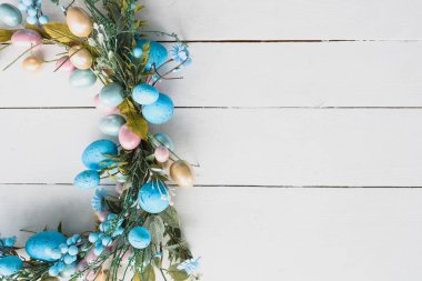 Paskalya Yumurtaları Bahar Arkaplanı. Tahta beyaz arka planda Paskalya çelengi