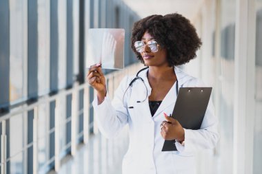 Doktor hastanede röntgen filmine bakıyor. Radyografi konsepti. Radyoloji kadın doktoru hastane odasındaki hastanın röntgen filmini inceliyor..