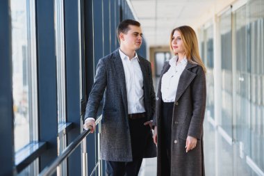 İş adamları ofis koridorunda yürür.