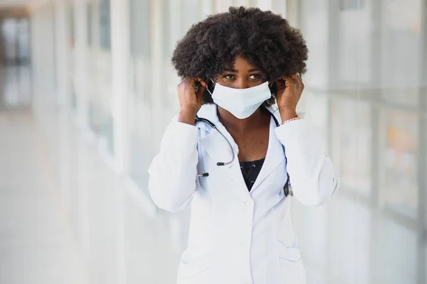 Young attractive african doctor with face mask