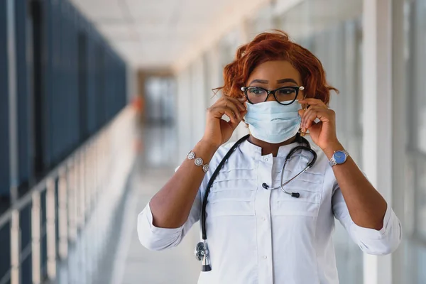 Young attractive african doctor with face mask