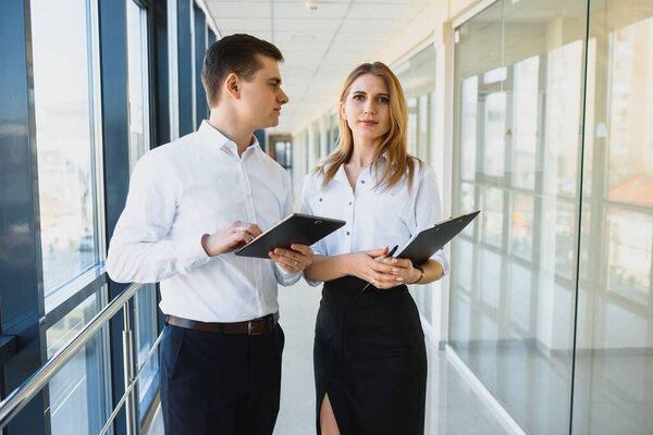 Счастливые коллеги по бизнесу в современном офисе с помощью планшета