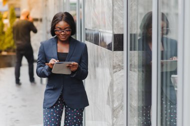 Dışarıda duran Afrikalı genç bir iş kadınının portresi.