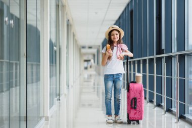 Havaalanında küçük sevimli bir çocuk içeride yatmayı bekliyor. Havaalanındaki sevimli küçük kız fast food yiyor ve çay içiyor.