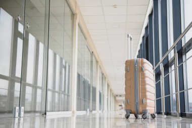 Havaalanından ayrılan bavullar, yaz tatili konsepti, havaalanı terminalinin bekleme salonunda seyahat valizleri, büyük pencereli boş koridor içi. bagaj havaalanı terminali arka planı.