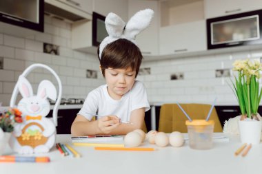 Paskalya yumurtalarını boyayan küçük çocuk. Paskalya yumurtalı mutlu çocuk