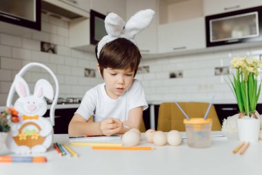 Paskalya yumurtalarını boyayan küçük çocuk. Paskalya yumurtalı mutlu çocuk