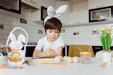 Paskalya yumurtalarını boyayan şirin bir çocuk. Paskalya yumurtalı mutlu çocuk