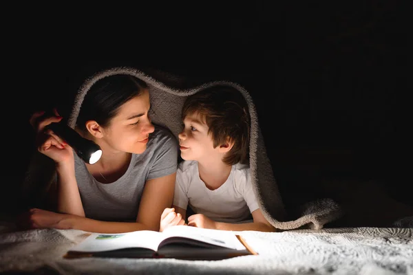Anne Küçük Oğlu Battaniyenin Altında Feneriyle Kitap Okuyorlar — Stok fotoğraf