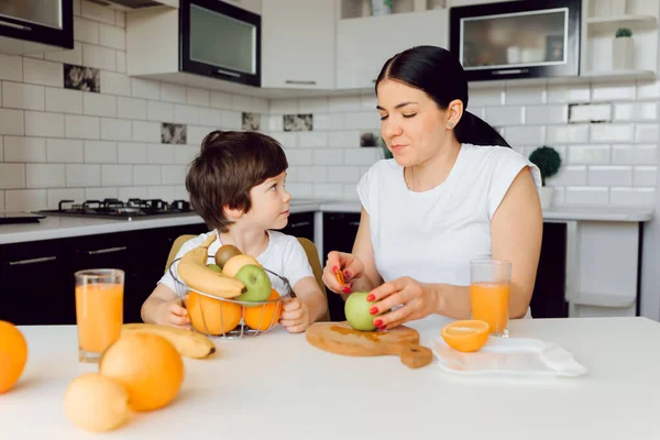 Healthy life and food concept. Healthy Eating. mom with baby drink juice and eat fruit