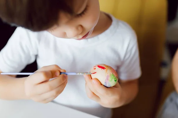 Little boy painting Easter eggs. Happy child with Easter eggs
