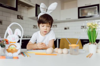 Paskalya yumurtalarını boyayan şirin bir çocuk. Paskalya yumurtalı mutlu çocuk