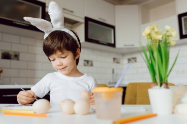 Paskalya yumurtalarını boyayan şirin bir çocuk. Paskalya yumurtalı mutlu çocuk