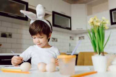 Paskalya yumurtalarını boyayan küçük çocuk. Paskalya yumurtalı mutlu çocuk