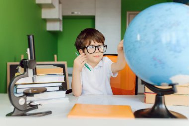 Çocuk evde çalışıyor ve ev ödevi yapıyor. Uzaklık öğrenimi çevrimiçi eğitim.