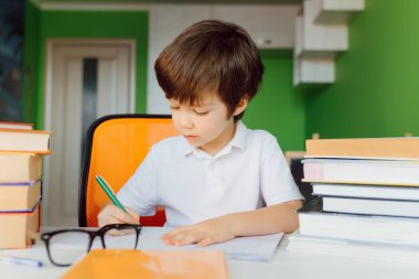 Stay at home, online learning, distance learning, self quarantine concept. Boy start doing homework with books notebooks for lesson at home clipart
