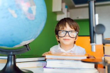 Çocuk evde CoVid-19 karantinası sırasında ders çalışıyor, uzaktan öğrenmeyi bilgisayarla öğreniyor, çocuk okul için ödev yapıyor. Okul çocuğu evde kaldı..