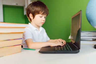 Çocuk evde defterle çalışıyor ve okul ödevi yapıyor. Uzaklık öğrenimi çevrimiçi eğitim.