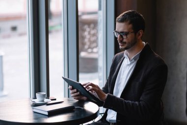 Cafe Table 'da oturan ve Tablet kullanan Mutlu Adam