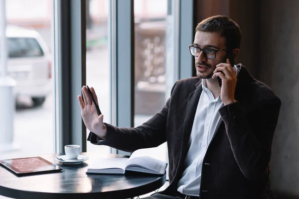 Handsome businessman talking on the phone in a cafe