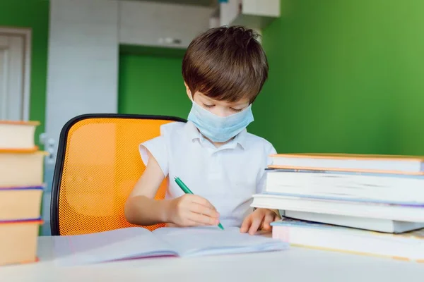 Niño Cansado Estudiando Casa Con Una Mascarilla Protectora Durante Cuarentena Imagen de archivo