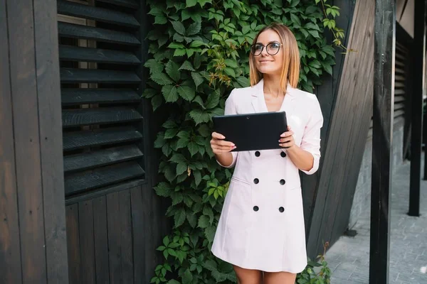 stock image Portrait of a successful businesswoman holding a digital tablet pad and a folder while proudly standing near office