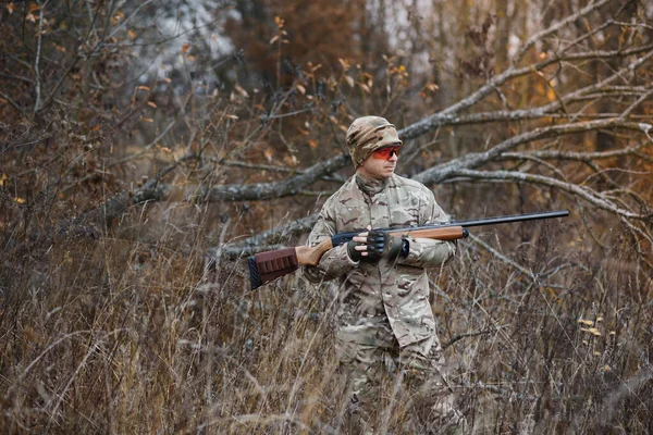 Hunter handsome guy with weapon. Hunter spend leisure hunting. Hunting equipment. Brutal masculine hobby. Man observing nature background. Hunter hold rifle. Safety measures. Natural environment.