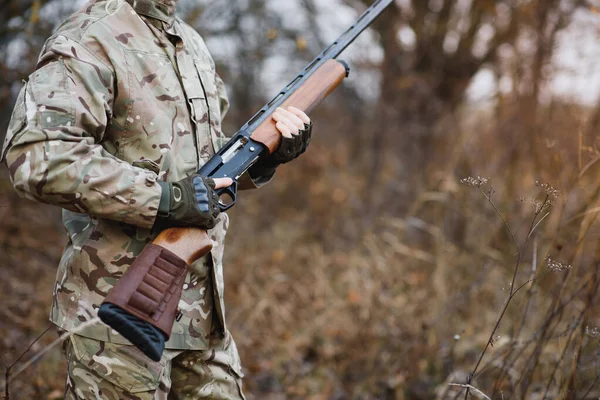 Hunter handsome guy with weapon. Hunter spend leisure hunting. Hunting equipment. Brutal masculine hobby. Man observing nature background. Hunter hold rifle. Safety measures. Natural environment.