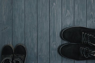 Ahşap arka plandaki erkekler için şık siyah çizmeler, reklam konsepti. Kış ve sonbahar erkek ayakkabıları koleksiyonu