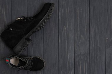 Ahşap arka plandaki erkekler için şık siyah çizmeler, reklam konsepti. Kış ve sonbahar erkek ayakkabıları koleksiyonu