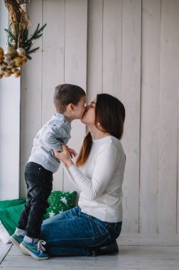 Güzel bir kadın ve sevimli küçük oğlu sarılıp gülümsüyor. Anne ve güzel bir oğlu var.