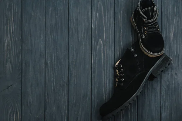 木制背景的男子时髦的黑色靴子 广告概念 冬季及秋季男鞋系列 — 图库照片