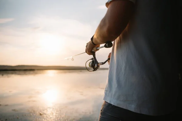 Ręce Rybaka Trzyma Spinning Rod Obraca Uchwyt Cewki Hobby Działalność — Zdjęcie stockowe